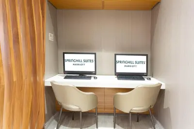 two computer screens sitting on a desk with two chairs at SpringHill Suites by Marriott Fort Lauderdale Miramar in Miramar