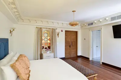 a bedroom with a white bed and a tv at The Villa Casa Casuarina in Miami Beach