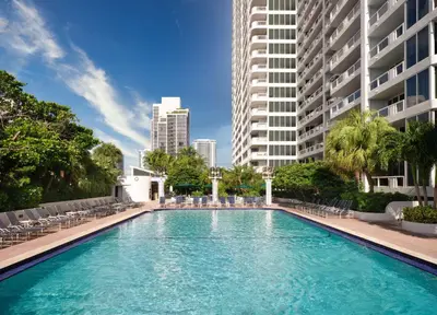 a large swimming pool with chairs and buildings at DoubleTree by Hilton Grand Hotel Biscayne Bay in Miami