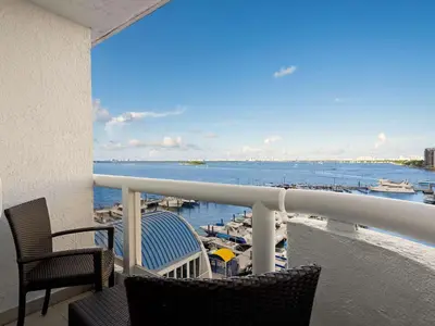 a balcony with chairs and a view of a marina at DoubleTree by Hilton Grand Hotel Biscayne Bay in Miami