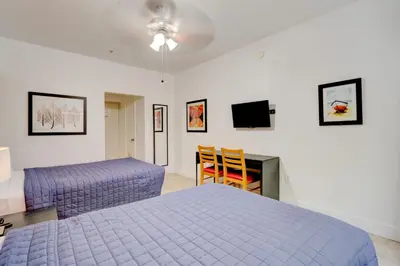 a bedroom with a bed and a desk and a tv at James Hotel in Miami Beach