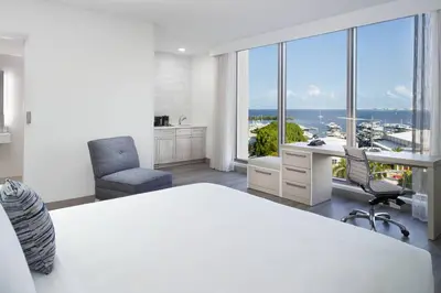a bedroom with a bed and a desk and chairs at Courtyard Miami Coconut Grove in Miami