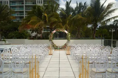 an aisle with white chairs and an arch with lights at Courtyard Miami Coconut Grove in Miami