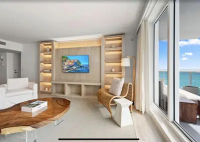 a bedroom with a bed and a living room with a table at 1 Hotel & Homes Miami Beach Oceanfront Residence Suites By Joe Semary in Miami Beach