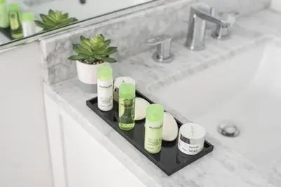 a bathroom sink with a shelf with products on it at Sobe Lux in Miami Beach