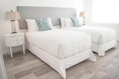 a white bedroom with two beds and a couch at Sobe Lux in Miami Beach