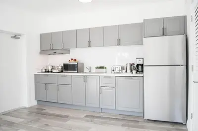 a kitchen with white cabinets and a refrigerator at Sobe Lux in Miami Beach