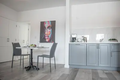 a kitchen with a table and chairs and a painting at Sobe Lux in Miami Beach