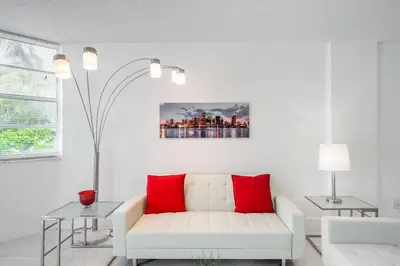 a living room with a white couch and red pillows at Luxury Miami Condos in Miami Beach