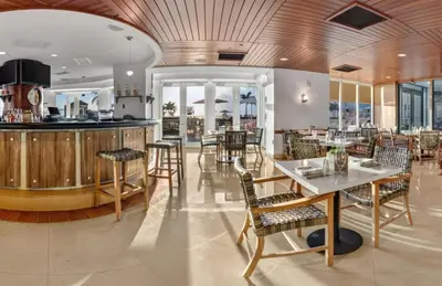 a restaurant with tables and chairs and a bar at Beach House Fort Lauderdale, A Hilton Resort in Fort Lauderdale