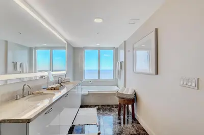 a bathroom with two sinks and a bath tub at Beach House Fort Lauderdale, A Hilton Resort in Fort Lauderdale