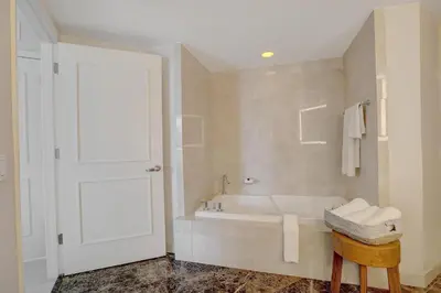 a white bathroom with a tub and a sink at Beach House Fort Lauderdale, A Hilton Resort in Fort Lauderdale
