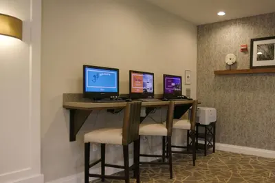 a bar with four computer monitors on a desk at Hampton Inn Hallandale Beach-Aventura in Hollywood