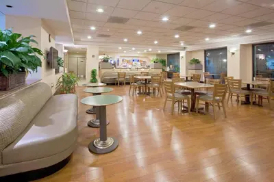 a restaurant with tables and chairs and a couch at Holiday Inn Express & Suites Miami - Hialeah by IHG in Hialeah