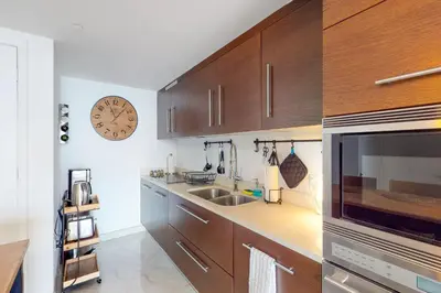 a kitchen with wooden cabinets and a clock on the wall at Iconic Views in Miami