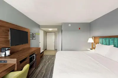 a hotel room with a bed and a flat screen tv at Hampton Inn & Suites Fort Lauderdale Airport in Hollywood