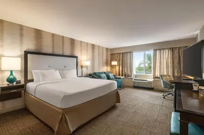 a hotel room with a large bed and a desk at Hampton Inn Pembroke Pines in Pembroke Pines