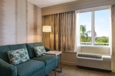 a living room with a couch and a large window at Hampton Inn Pembroke Pines in Pembroke Pines