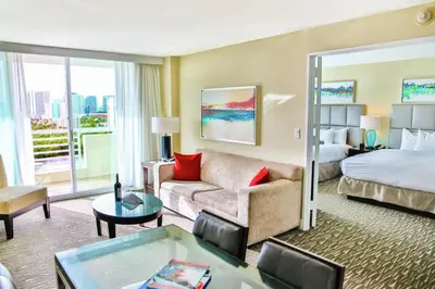 a hotel room with a bed and a living room at GALLERY One - A DoubleTree Suites by Hilton Hotel in Fort Lauderdale