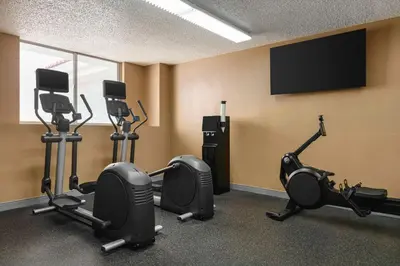 a gym with several exercise bikes and a flat screen tv at Embassy Suites by Hilton Fort Lauderdale 17th Street in Fort Lauderdale
