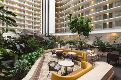 a courtyard with tables and chairs in a building at Embassy Suites by Hilton Fort Lauderdale 17th Street in Fort Lauderdale