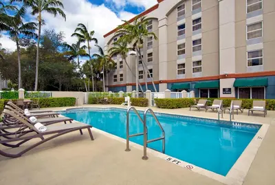 a pool at a hotel with lounge chairs and a building at Hampton Inn Ft Lauderdale Airport North Cruise Port in Fort Lauderdale