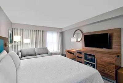 a hotel room with a bed and a flat screen tv at Hampton Inn Ft Lauderdale Airport North Cruise Port in Fort Lauderdale