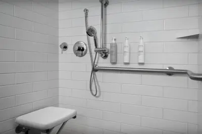 a shower in a white tiled bathroom with a toilet at Hampton Inn Fort Lauderdale Downtown Las Olas Area in Fort Lauderdale