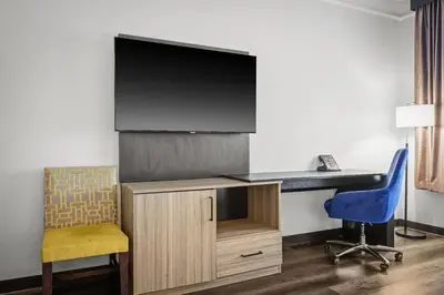 a room with a tv and a desk and a chair at La Quinta by Wyndham Miami Airport West in Miami