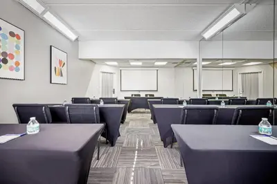 a conference room with tables and chairs and a whiteboard at La Quinta by Wyndham Miami Airport West in Miami
