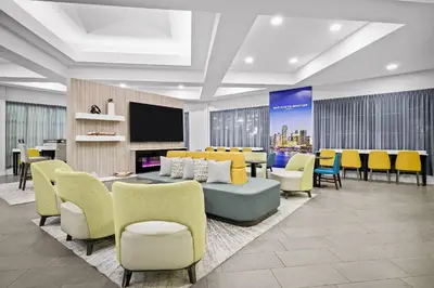 a lobby with a table and chairs and a tv at La Quinta by Wyndham Miami Airport West in Miami