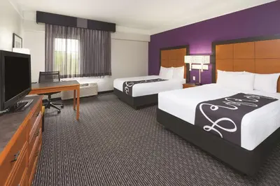 a hotel room with two beds and a flat screen tv at La Quinta by Wyndham Miami Airport East in Miami