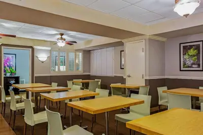 a dining room with wooden tables and chairs at La Quinta by Wyndham Miami Lakes in Miami Lakes