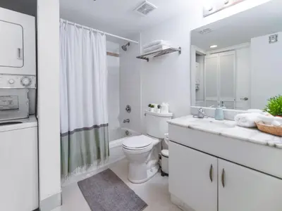 a white bathroom with a toilet and a sink at Beautiful Apartment in the Heart of Brickell in Miami