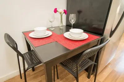 a dining room table with two chairs and a table with a red table cloth at Apartments in the Heart of Miami - Port of Miami / Miami Airport in Miami