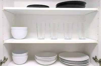 a white shelf with plates and bowls and glasses at Apartments in the Heart of Miami - Port of Miami / Miami Airport in Miami