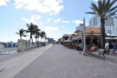 a man sitting on a bench next to the beach at Renovated studio wocean view boardwalk steps in Hollywood
