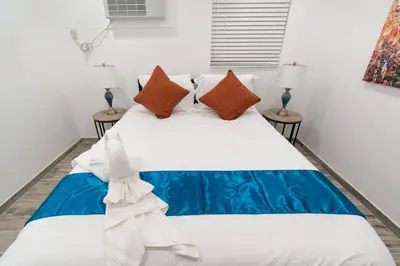 a bedroom with a blue and white bed with two lamps at Modern apt wqueen bed beach steps in Hollywood