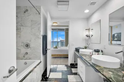 a white bathroom with two sinks and a tub and a shower at Marvelous apartment in Brickell in Miami