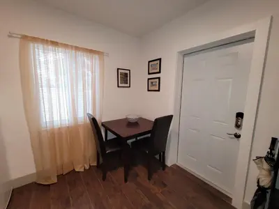 a dining room with a table and chairs and a door at Suite Life at Chez Mercedes in Miami