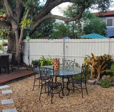 a table and chairs in a yard with a fence at Suite Life at Chez Mercedes in Miami