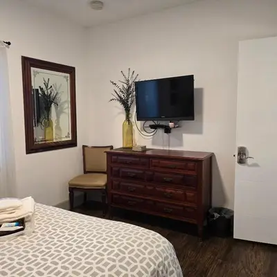 a bedroom with a bed and a tv on a dresser at Suite Life at Chez Mercedes in Miami