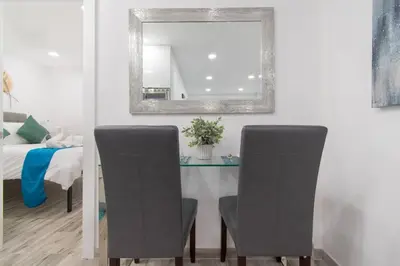a dining room table with two chairs and a mirror at Cozy apartment wsteps to beach boardwalk in Hollywood