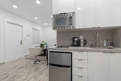 a kitchen with white cabinets and a microwave at Cozy apartment wsteps to beach boardwalk in Hollywood