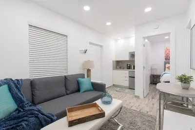a living room with a gray couch and a table at Modern studio wqueen bed beach views in Hollywood