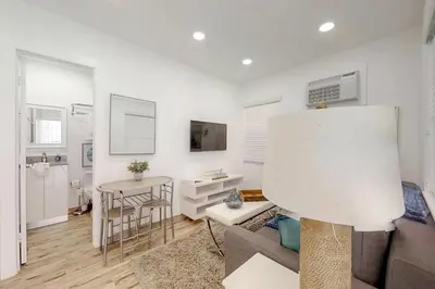 a living room with a couch and a table at Modern studio wqueen bed beach views in Hollywood