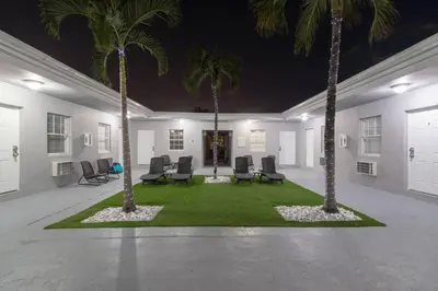 a room with palm trees and chairs in it at Modern apartment wking bed beach views in Hollywood