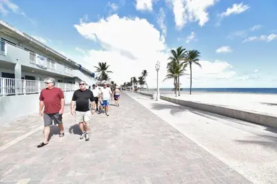 a group of people walking down a sidewalk near the beach at Modern apartment wking bed beach views in Hollywood