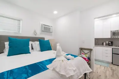 a bedroom with a large bed with blue and white at Renovated studio w ocean views boardwalk steps in Hollywood
