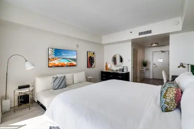 a bedroom with a white bed and a couch at Ocean View Balcony steps from Restaurants, Peacock Park & Marina in Miami